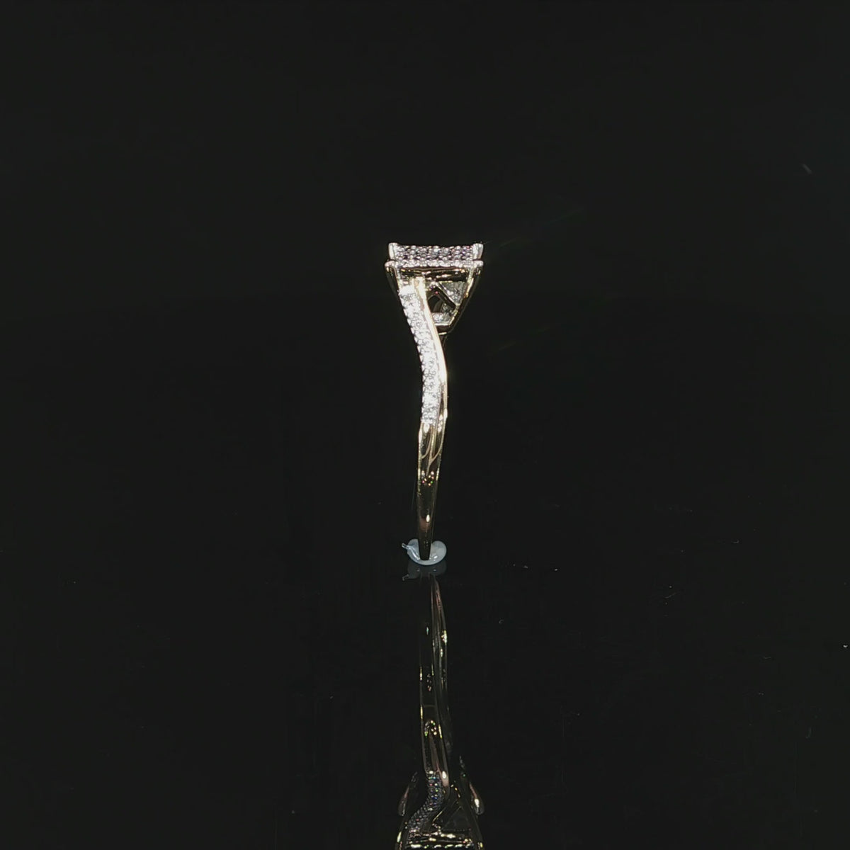 Video of natural diamond ring standing edge-on, with its curved 10K yellow gold band reflected below.