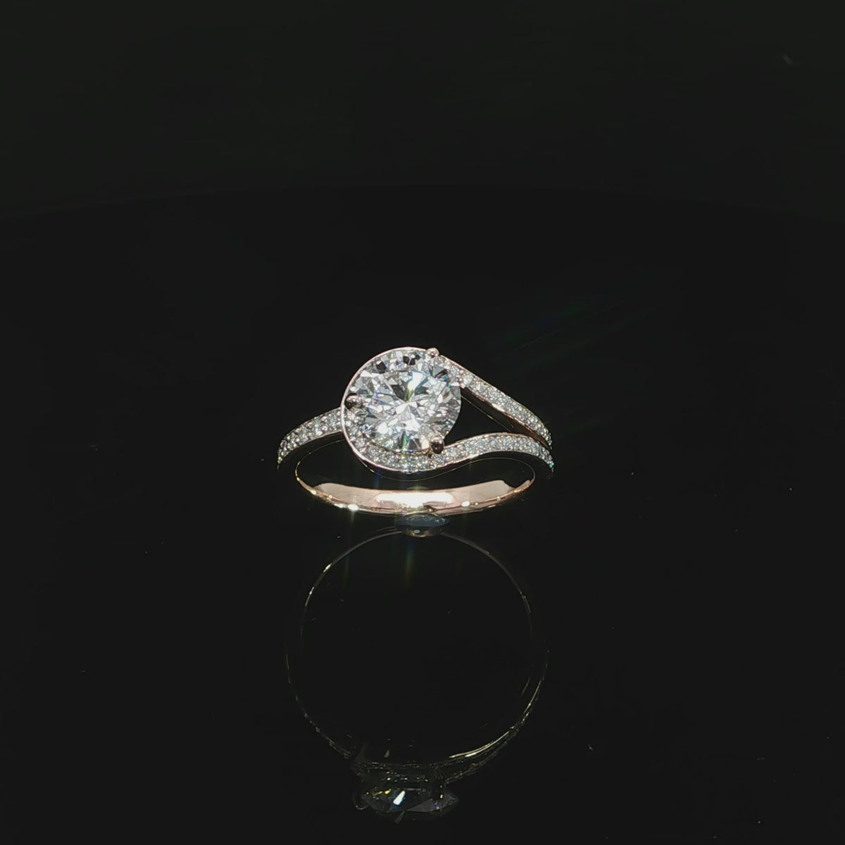 Unique 14K rose gold bypass engagement ring with a round lab grown center diamond and pavé accents.