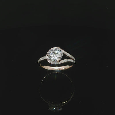 Unique 14K rose gold bypass engagement ring with a round lab grown center diamond and pavé accents.