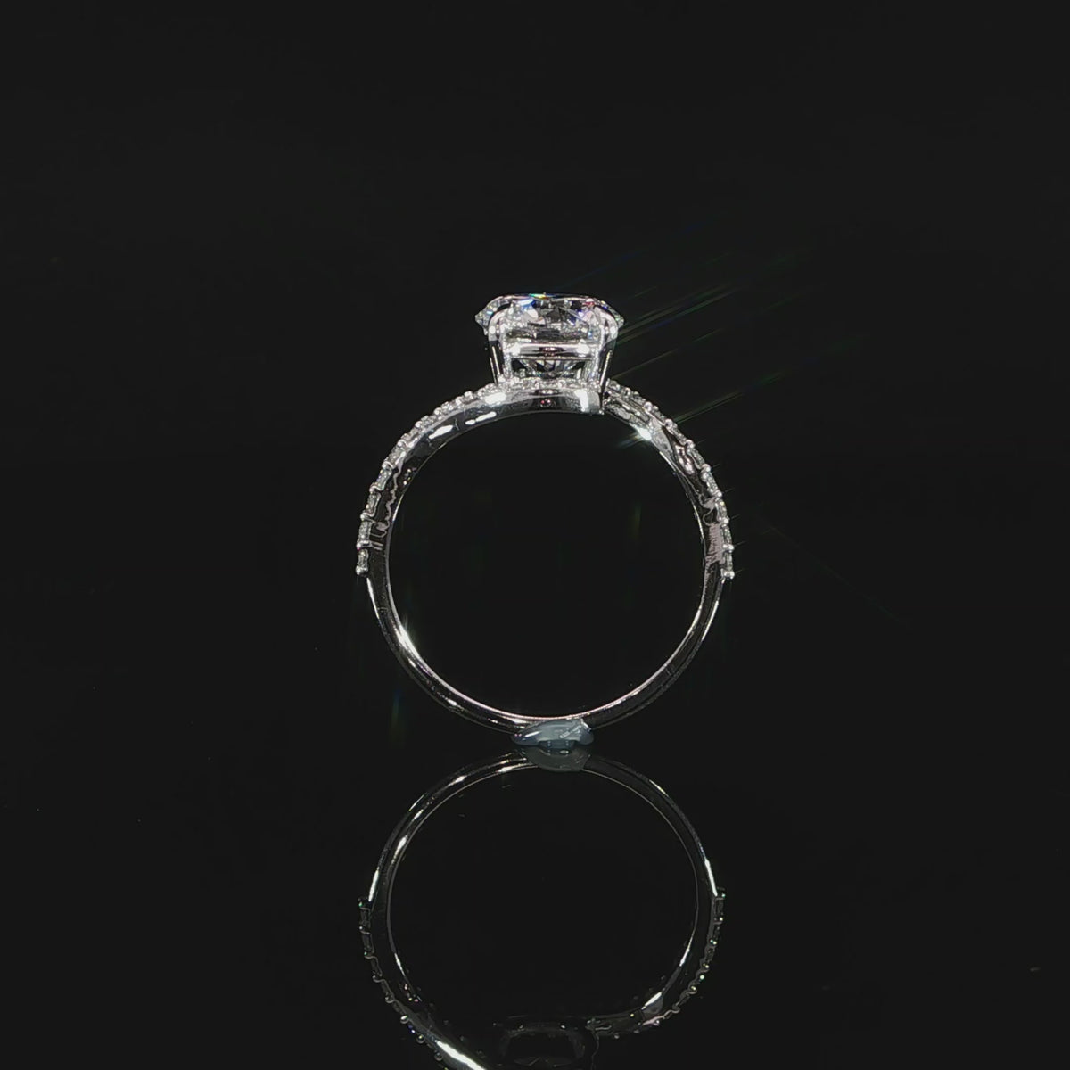 Detailed view of the bypass setting curving around the 2-carat round center diamond.
