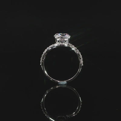 Detailed view of the bypass setting curving around the 2-carat round center diamond.