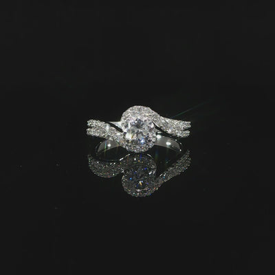 Unique round diamond bypass engagement ring with a pavé-set band and sweeping asymmetrical design.