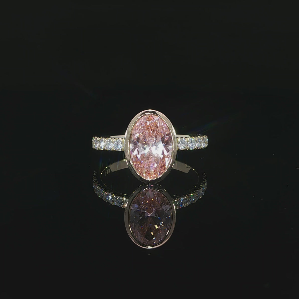 Close-up of the oval pink center diamond and its faceted surface.