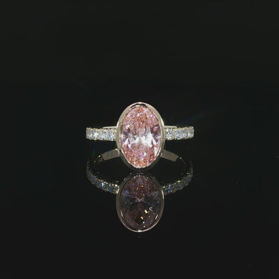 Close-up of the oval pink center diamond and its faceted surface.