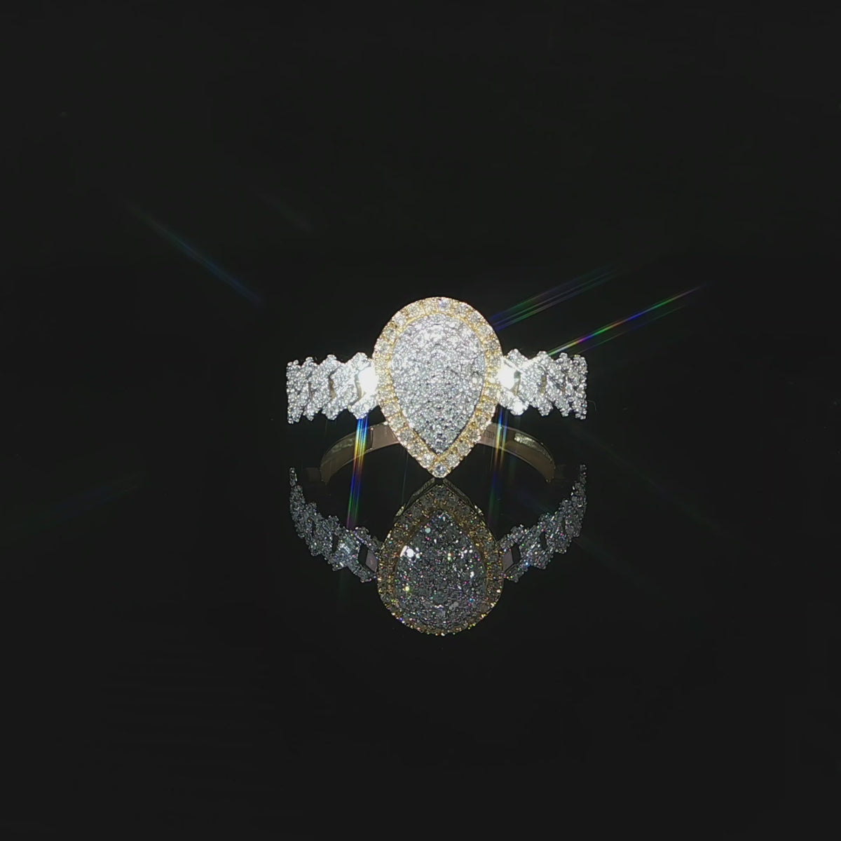 A 10K yellow gold 0.38 CTW pear cluster halo ring video, revealing interlocking diamond shoulders.