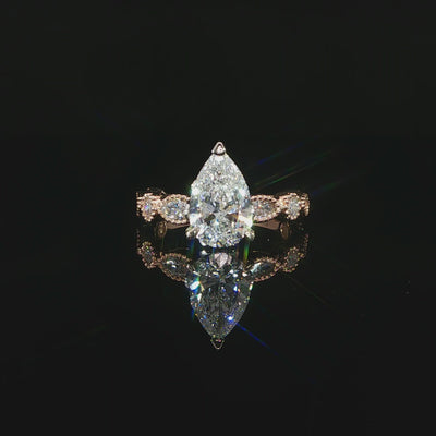 2.71 CTW lab grown diamond engagement ring with a 2 carat pear center stone in 14K rose gold.