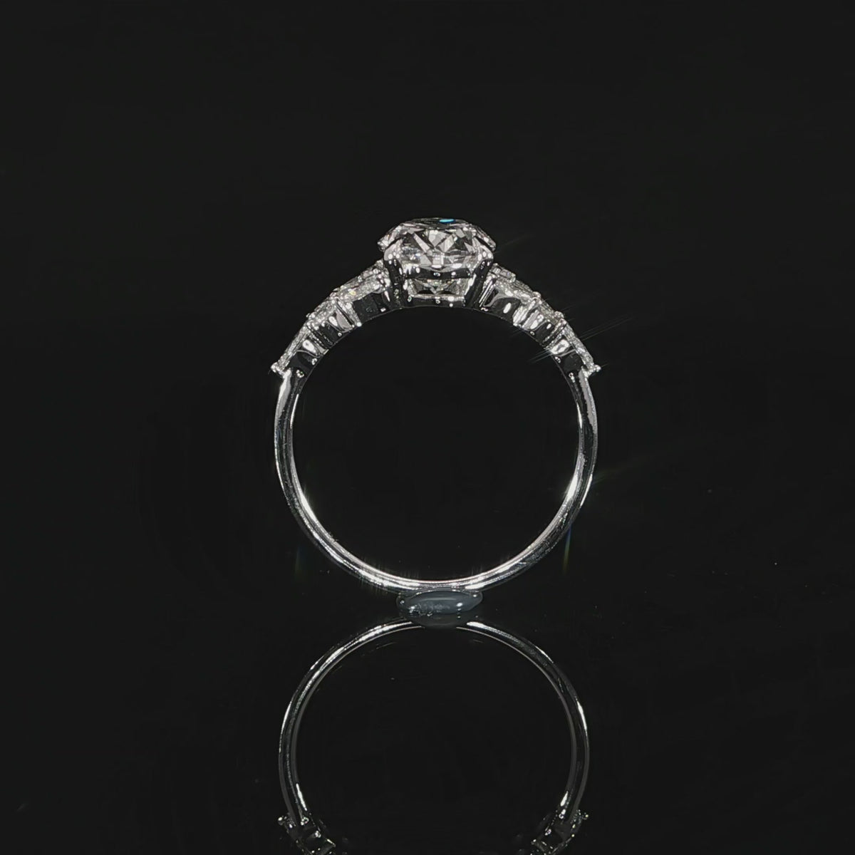 Detailed view of the oval diamond setting with marquise and round side accents extending along the shoulders.
