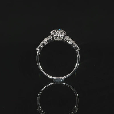 Detailed view of the oval diamond setting with marquise and round side accents extending along the shoulders.