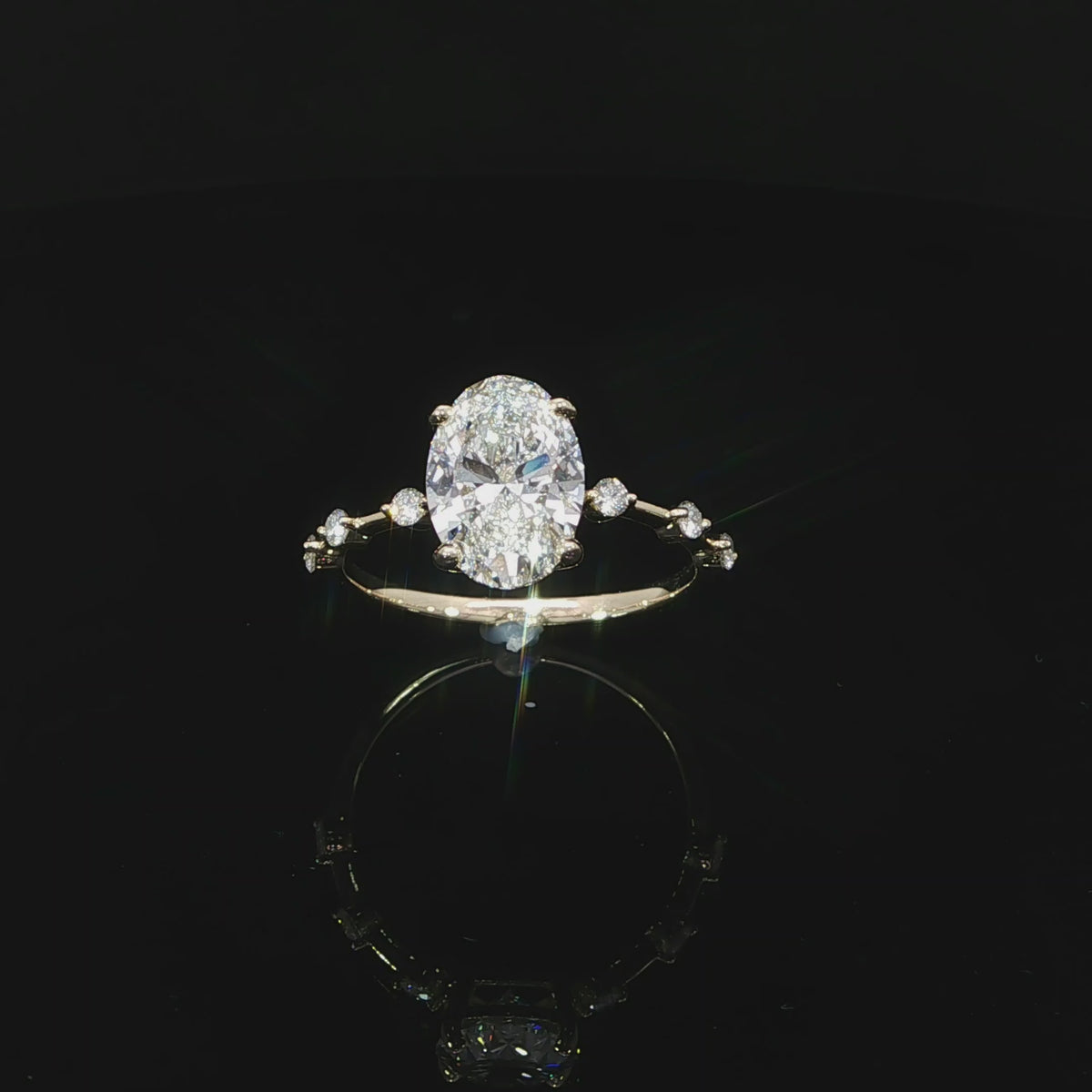 Top view of a yellow gold oval engagement ring with spaced diamonds along the band.