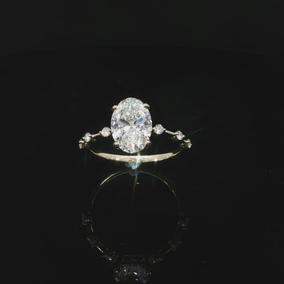 Top view of a yellow gold oval engagement ring with spaced diamonds along the band.