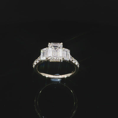 Emerald cut center diamond engagement ring with matching emerald cut side stones in a three-stone design.