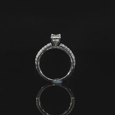 Video of 1 carat emerald-cut diamond held above a slender 14K white gold diamond band.