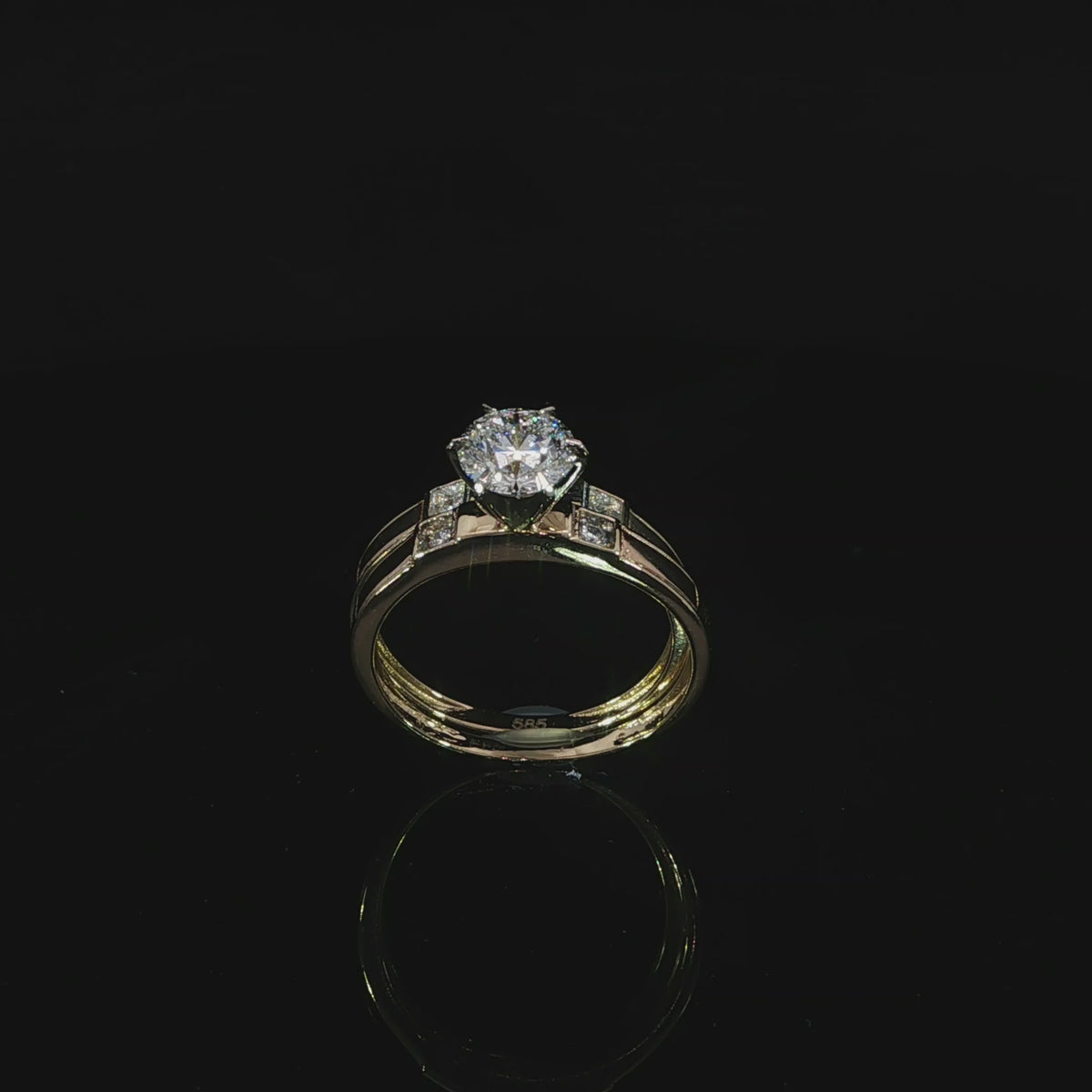 Yellow gold solitaire and matching accent band in a tilted profile with a reflection on black.
