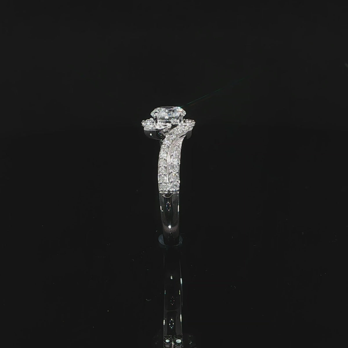 Video of a round center diamond framed by curved pavé bypass bands in white gold.