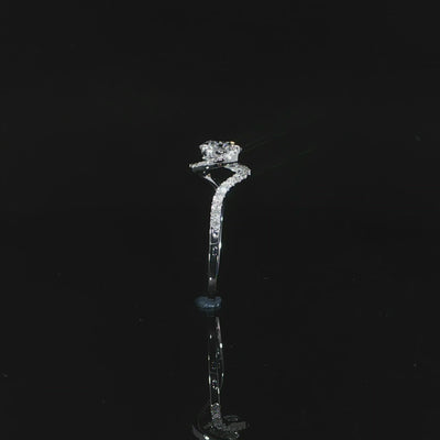 Side detail video of the raised round diamond setting above the white gold band and diamond shoulder.