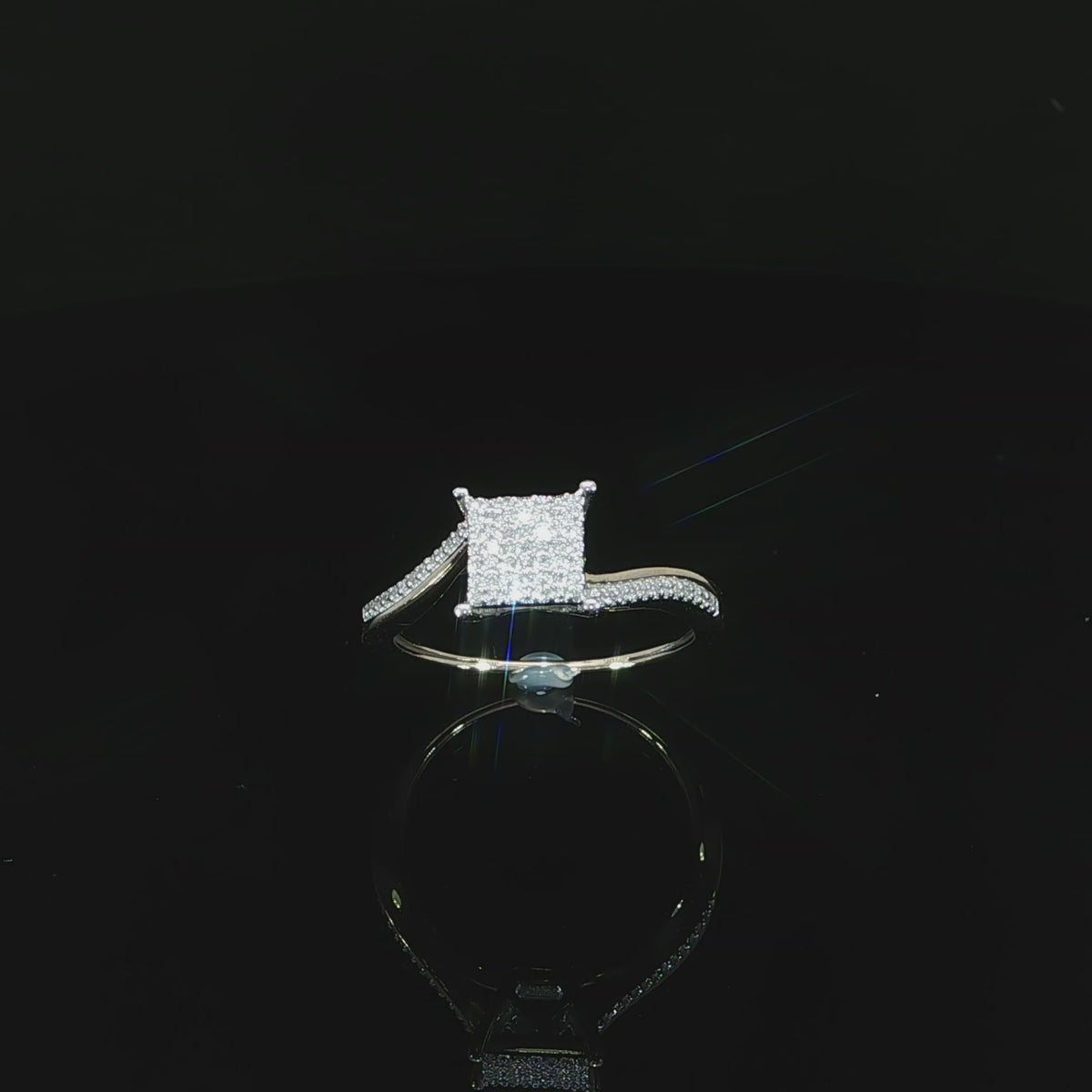 Upright video of a 10K yellow gold cluster ring with a diamond-accented shoulder and open setting.