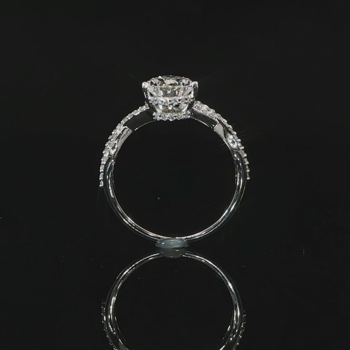 Close view video of the intertwined diamond-accented band supporting the pear-shaped center stone.
