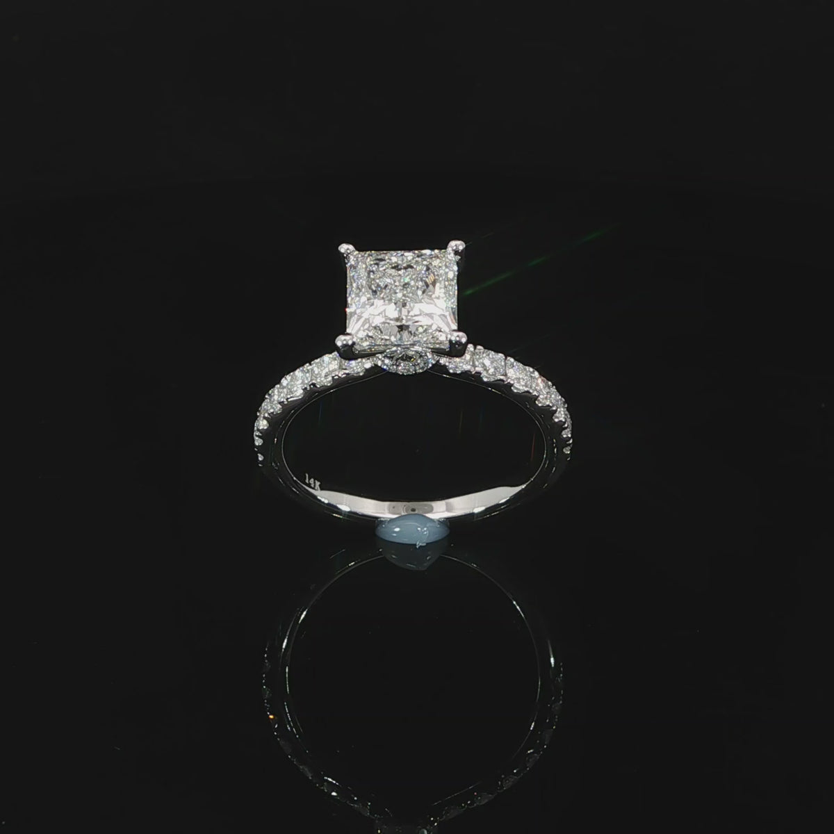 Top view of 2 carat princess cut solitaire engagement ring with pave diamond band.