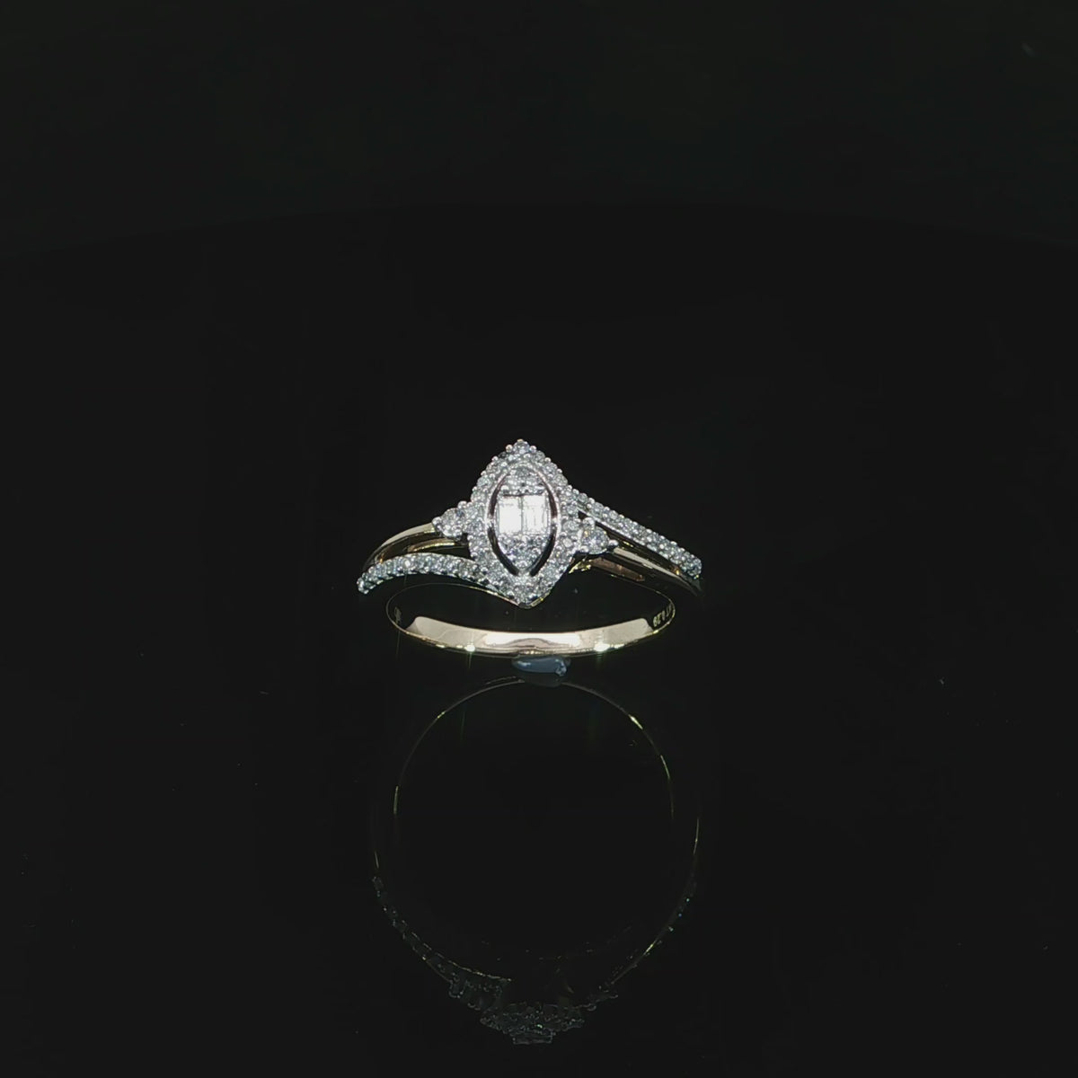 Tilted view of a 10K yellow gold 0.29 CTW marquise-shaped illusion halo ring with diamond-set and polished shoulders.