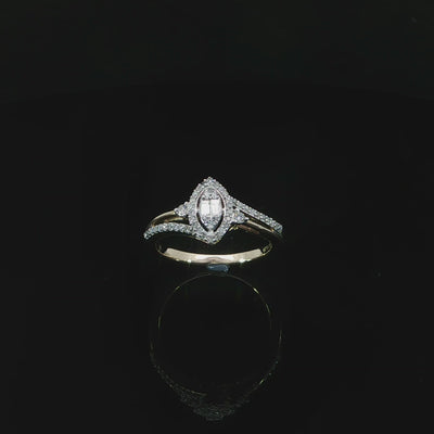 Tilted view of a 10K yellow gold 0.29 CTW marquise-shaped illusion halo ring with diamond-set and polished shoulders.