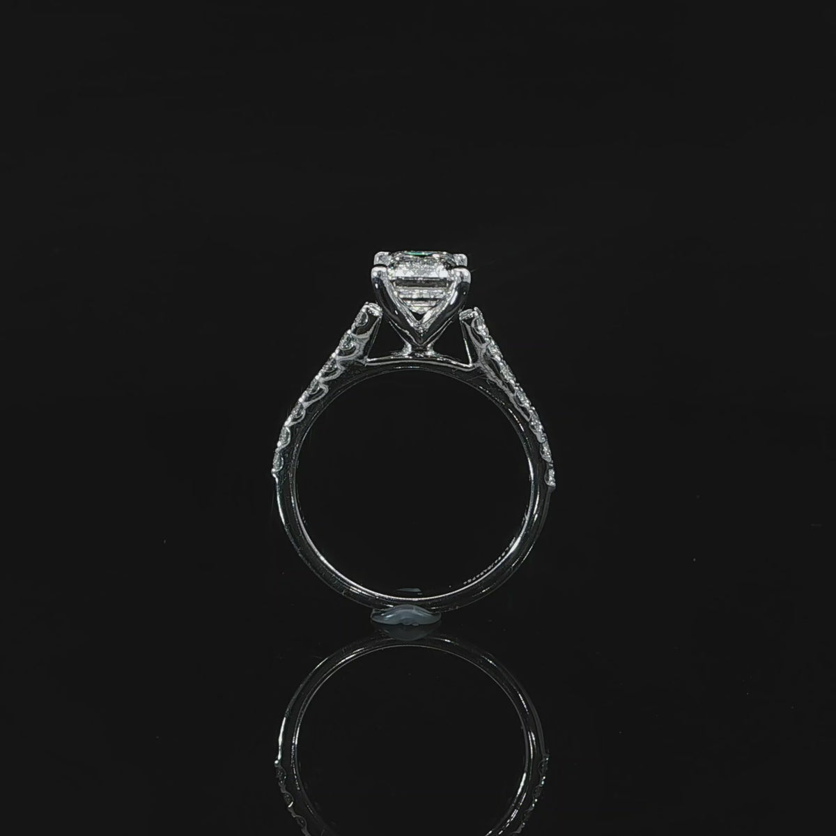 Side video of a 2 carat emerald cut diamond engagement ring with a pavé band and elevated center stone.
