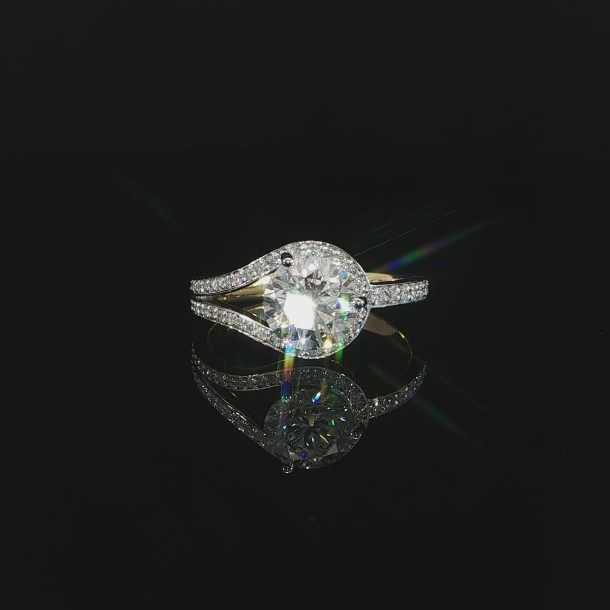 Detailed video of a round center diamond framed by split pavé bypass bands in 14K yellow gold.