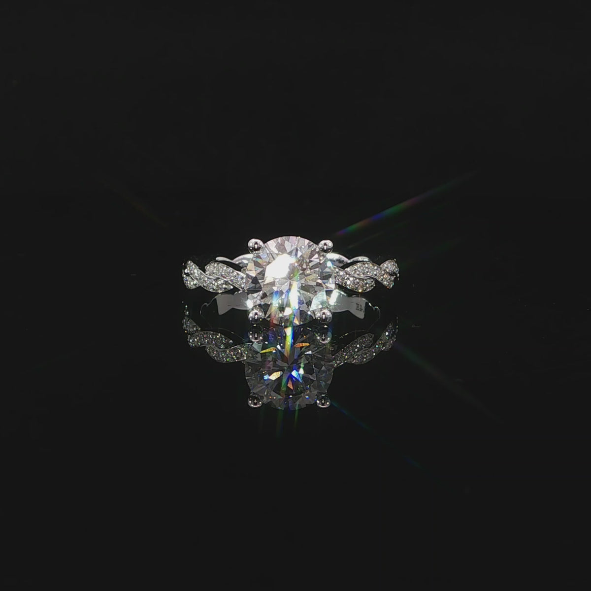 Video of 2ct round center diamond framed by four prongs and pavé twists on both shoulders