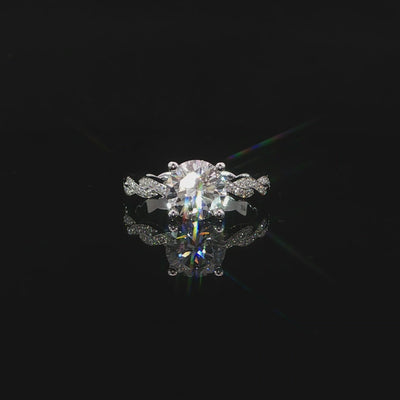 Video of 2ct round center diamond framed by four prongs and pavé twists on both shoulders