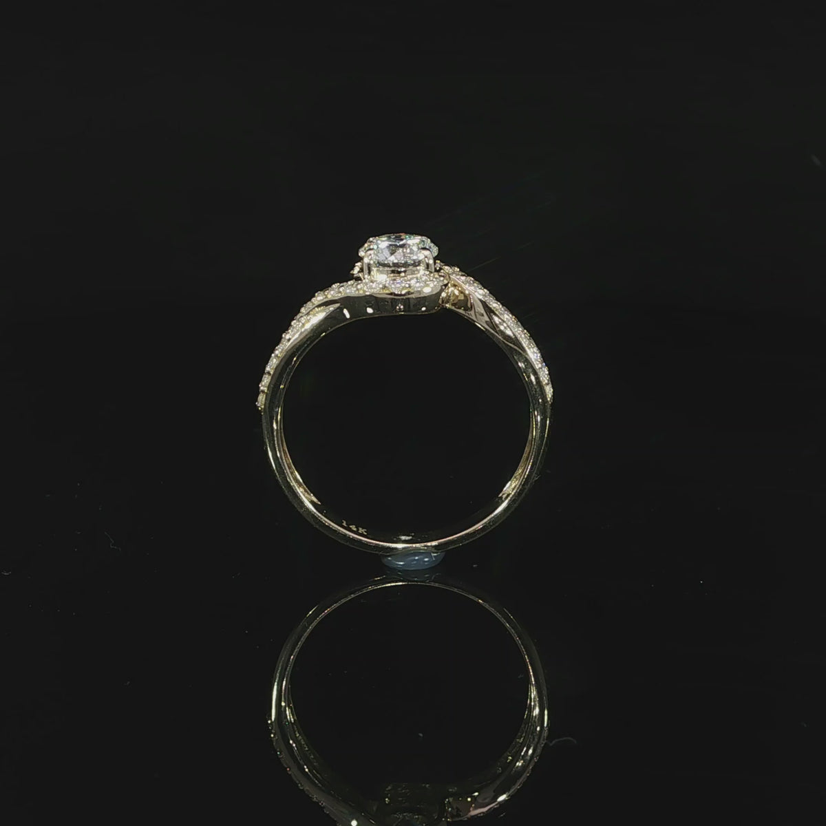 Side video of a round bypass diamond ring showing the raised center setting and pavé shoulders.