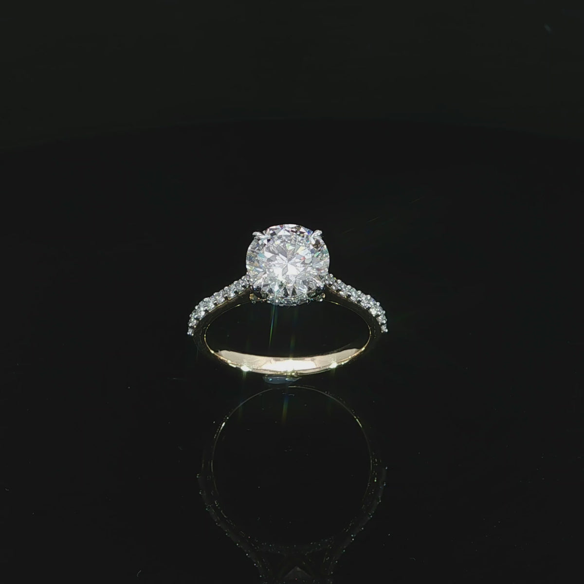 Modern round diamond engagement ring with a hidden halo, cathedral setting, and diamond-accented band.