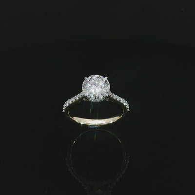 Modern round diamond engagement ring with a hidden halo, cathedral setting, and diamond-accented band.