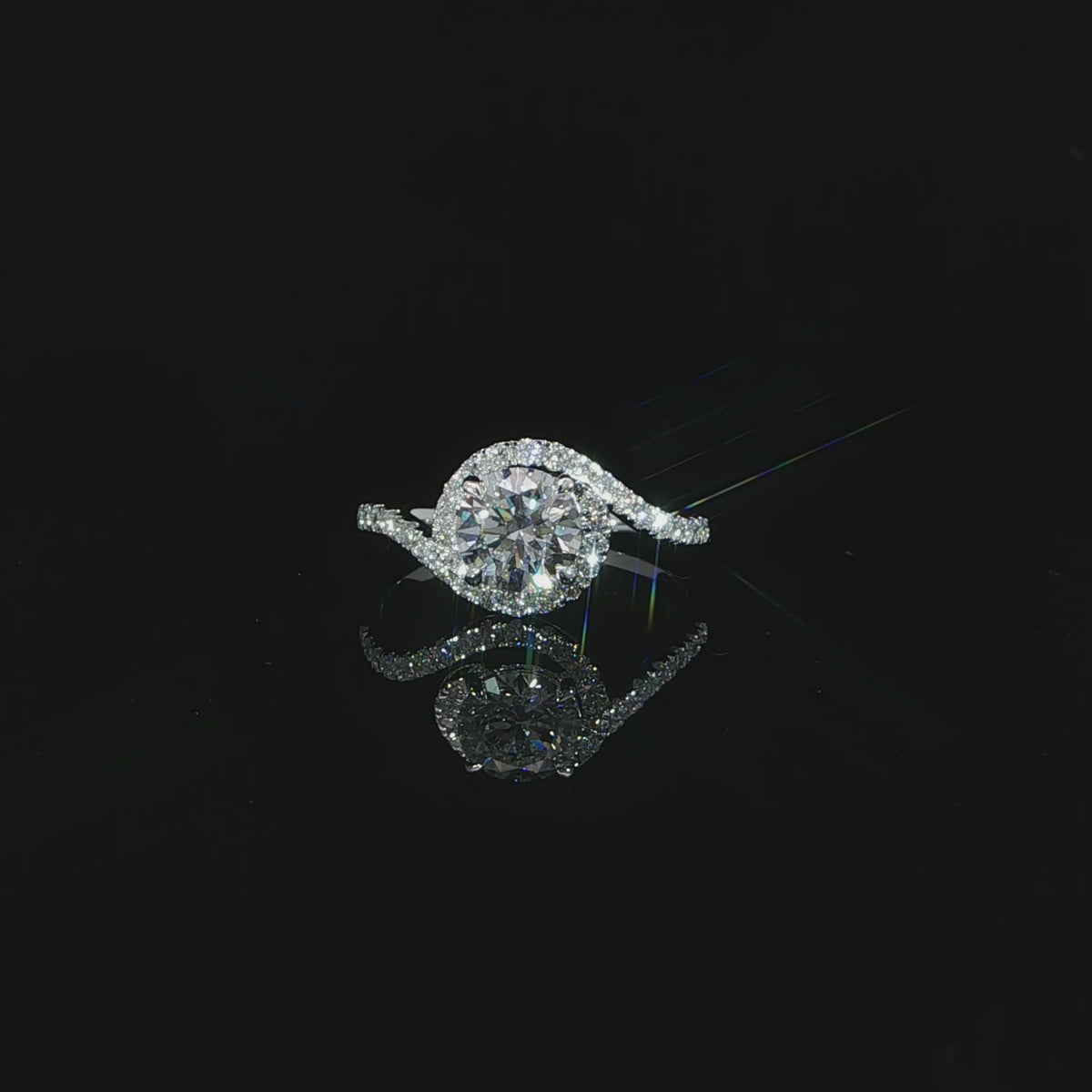 Close-up detailed video of the flowing diamond-set curve sweeping beside the round center stone.