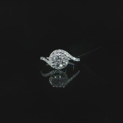 Close-up detailed video of the flowing diamond-set curve sweeping beside the round center stone.