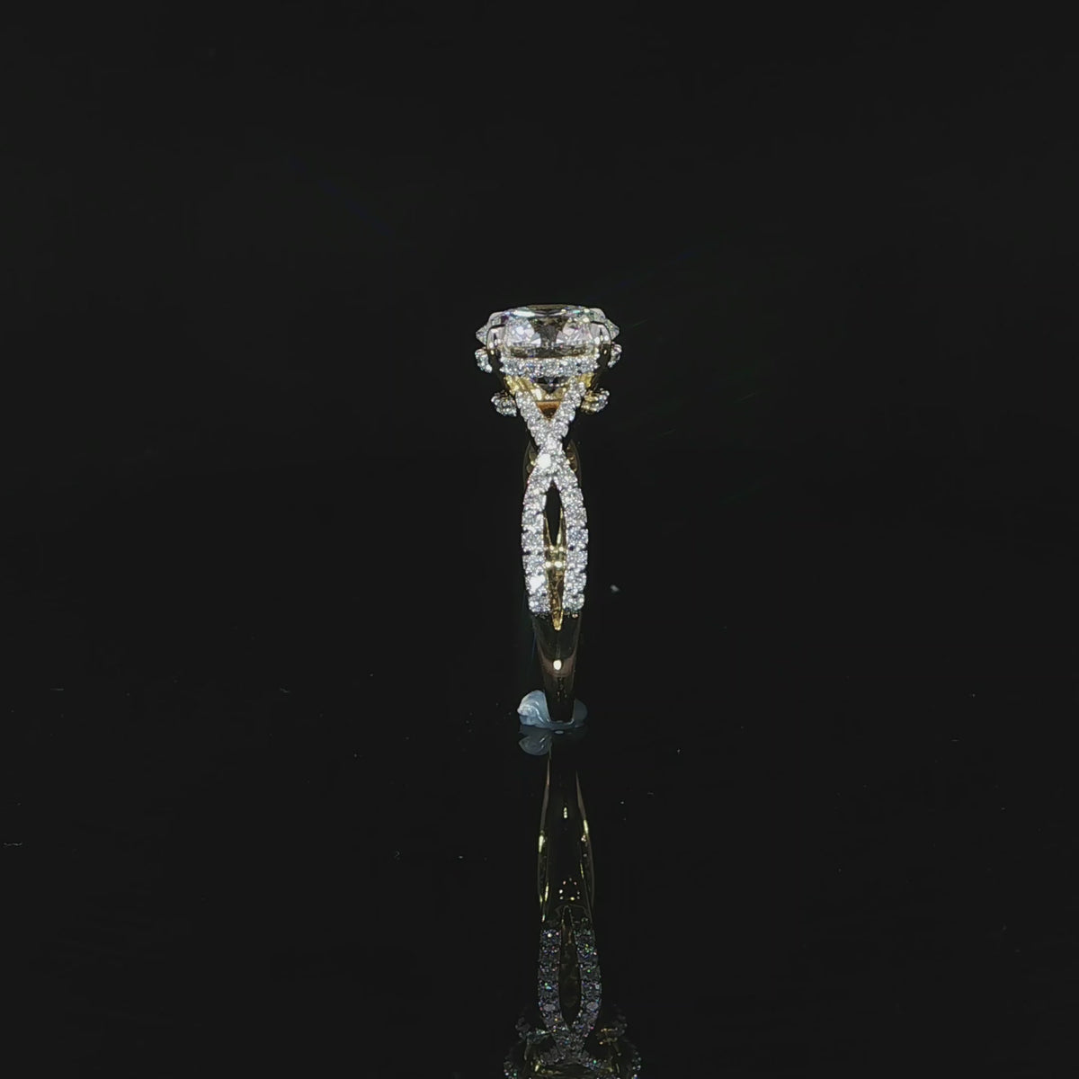 Close view of the intertwined diamond-accented band crafted in polished yellow gold.