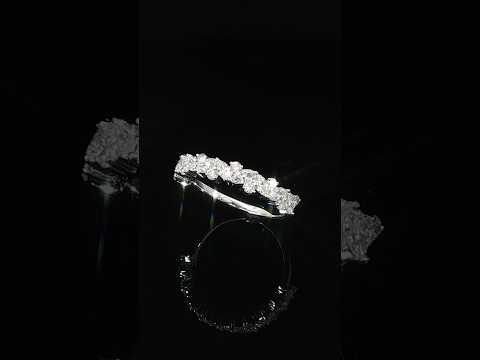 Angled view of a 14K white gold multi-shape diamond band with a staggered arrangement of stones.