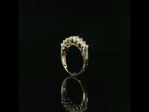 Polished gold shoulder beside the multi-row diamond setting of a 14K yellow gold anniversary ring.