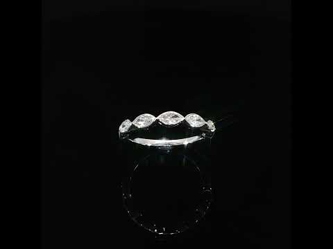 Angled view showing the pointed outlines of east-west marquise diamonds framed by smooth white gold bezels.