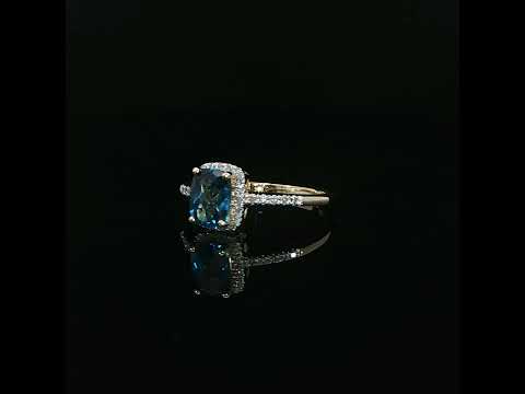 Front view of a natural blue topaz framed by a diamond halo in 14K yellow gold, 0.09 CTW diamonds.