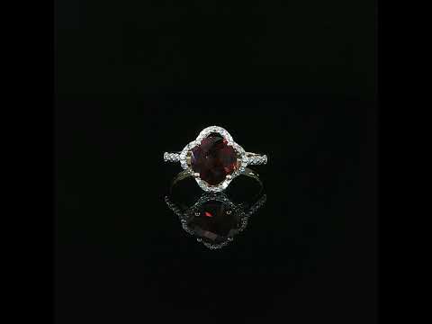 14K yellow gold red garnet ring with 0.10 CTW diamonds and a mirrored reflection beneath it.