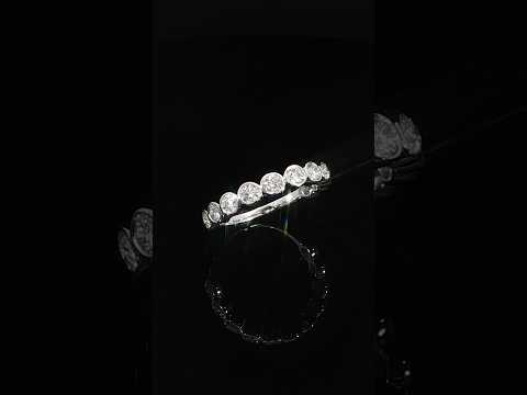 Angled detail of individually bezel-set lab-grown diamonds above a smooth 14K white gold shank.