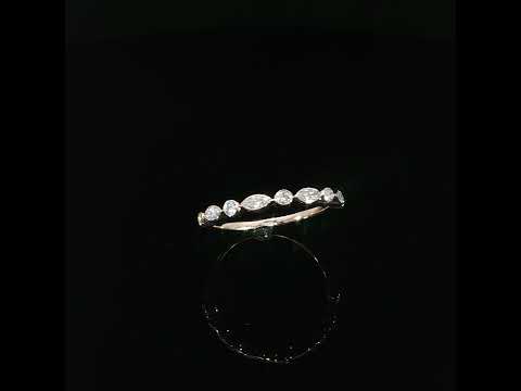 Angled profile of a modern 14K rose gold diamond band highlighting its slim polished shank bezel set diamonds.