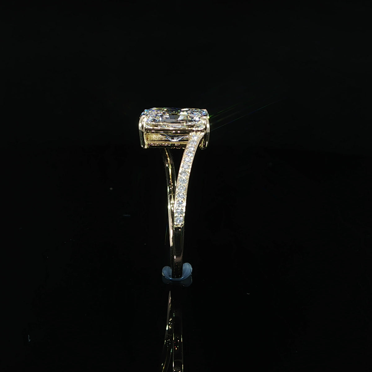 Standing side profile of a radiant diamond bypass ring with diamond-accented shoulders