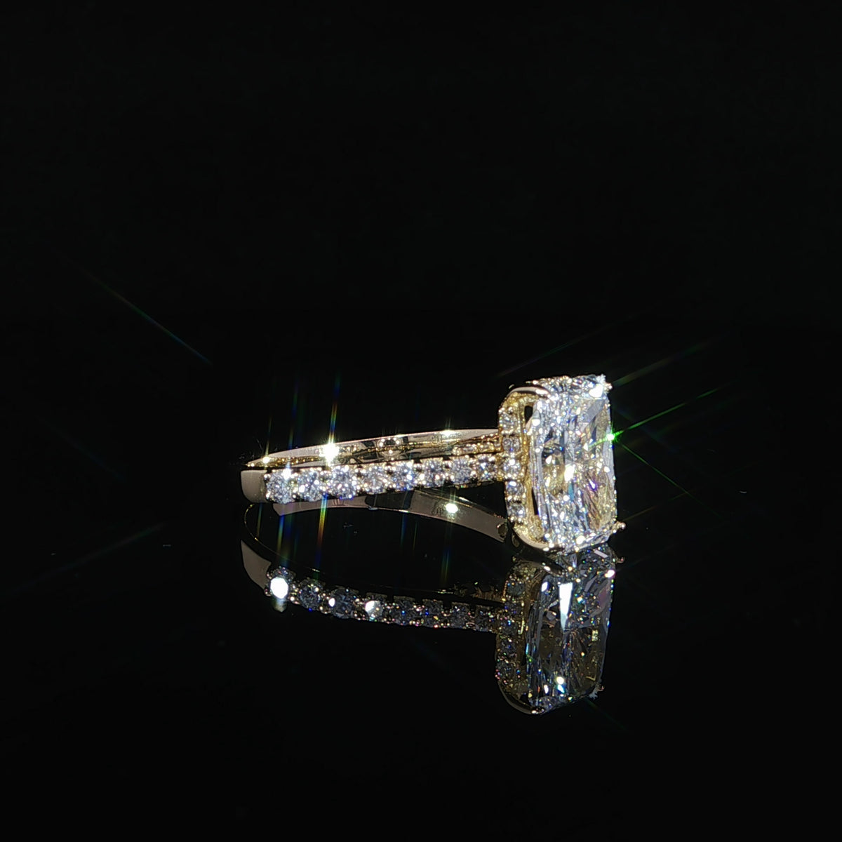  Side view of a yellow gold 2ct radiant diamond ring with a hidden halo