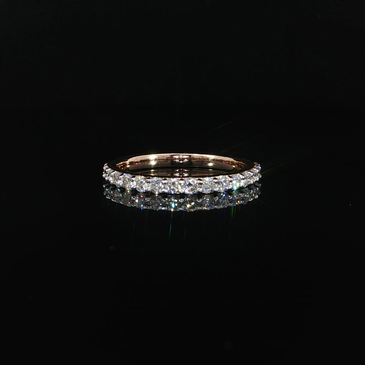 Rose gold band featuring 0.55 CTW of lab-grown diamonds on a reflective black surface.
