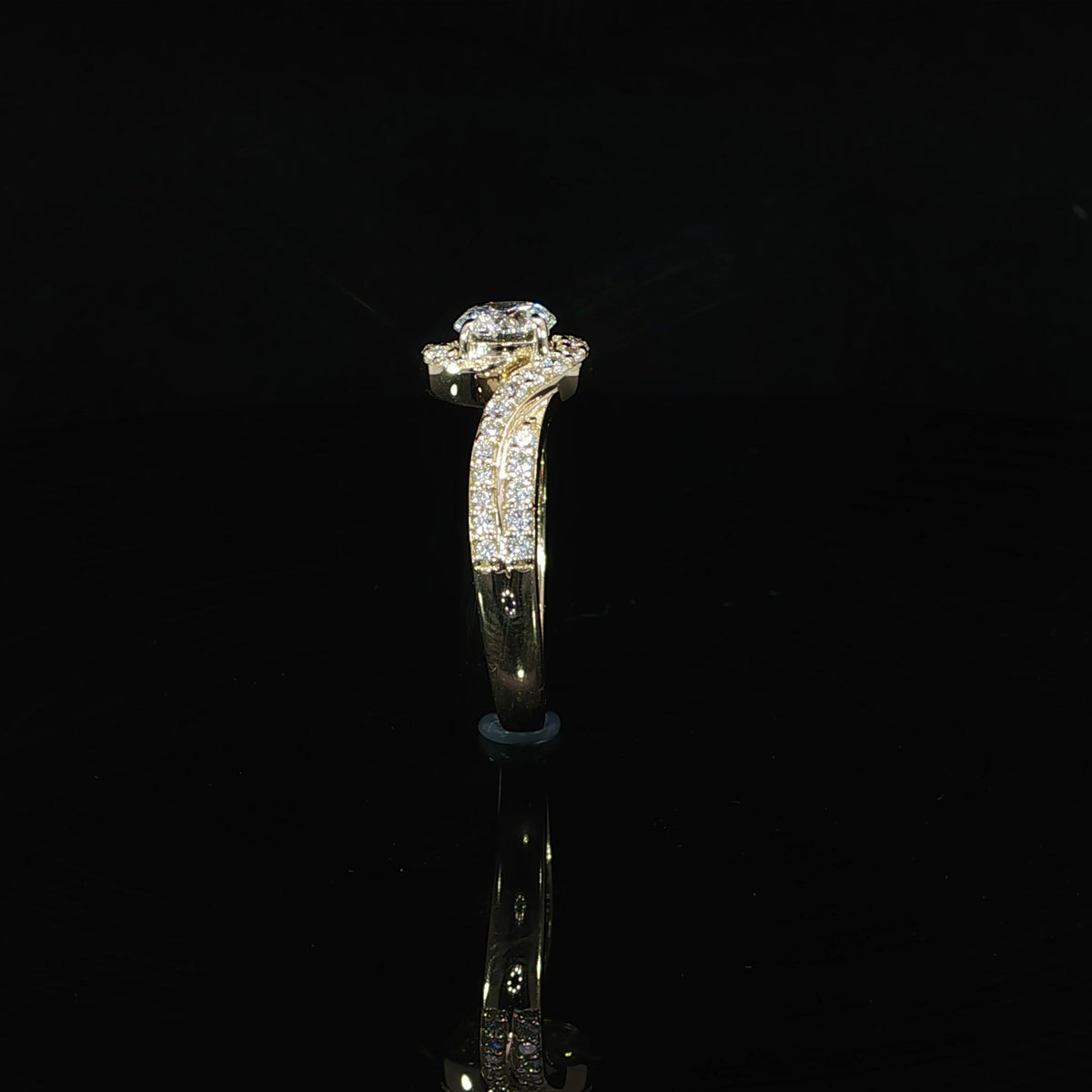 Side profile of a round bypass diamond ring showing the raised center setting and pavé shoulders.