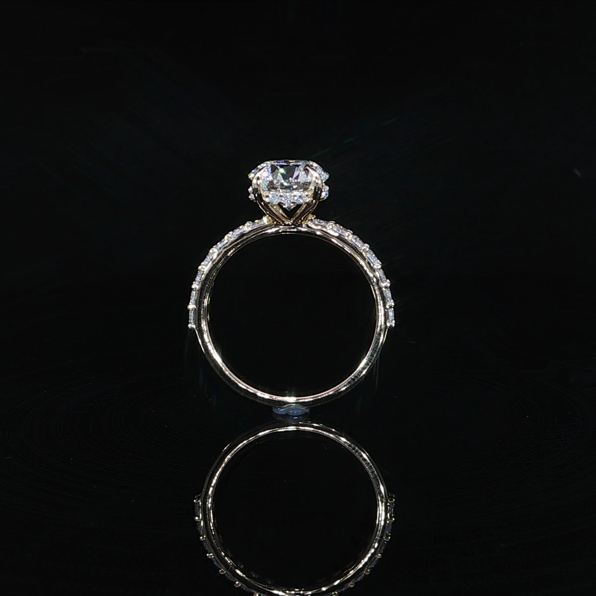 Detailed view of the hidden halo encircling the base of the 2 carat round center diamond.