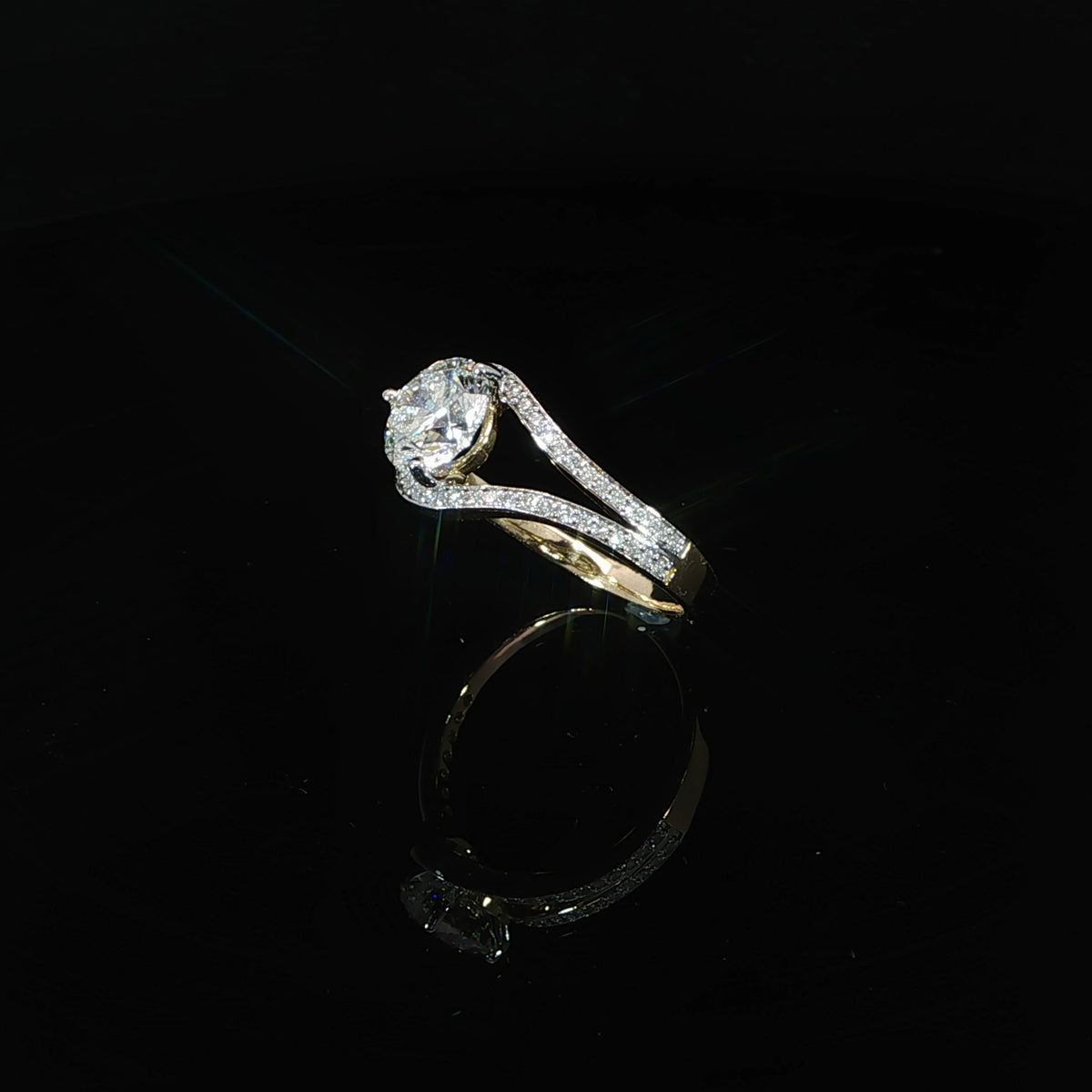 Side profile of a round diamond bypass ring showing the raised center setting and pavé diamond shoulders.