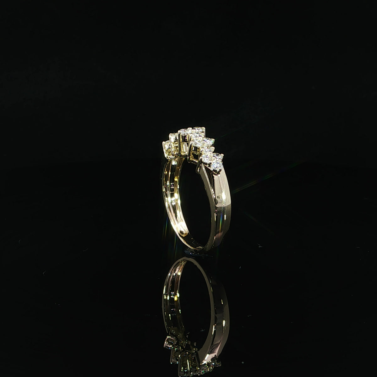 Angled detail of round lab-grown diamond clusters held in prong settings above a gold shank.