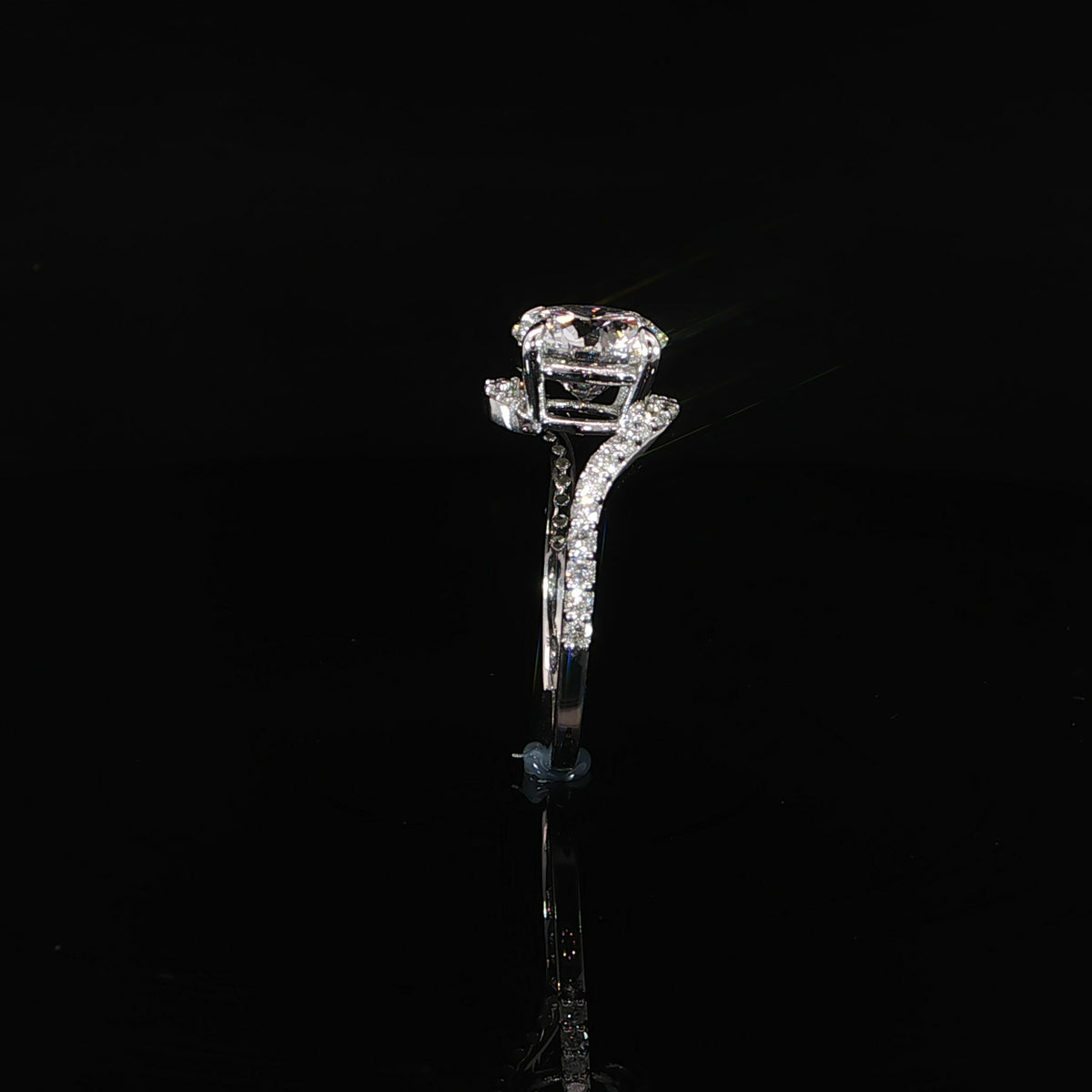 Side profile of a round lab-grown diamond ring showing its elevated setting and sweeping bypass band.