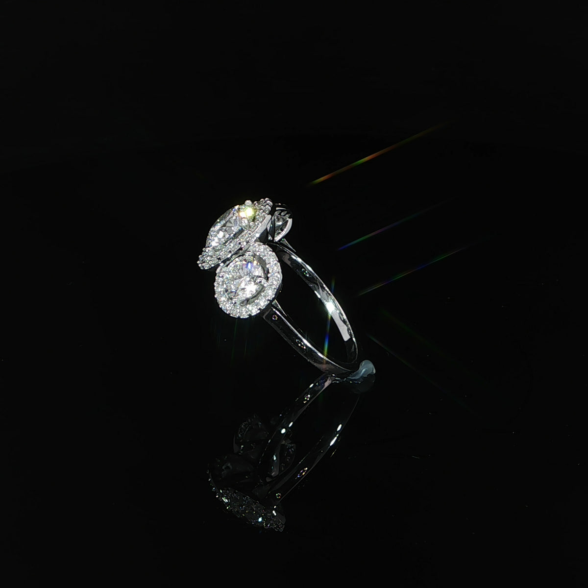 Side angle of a 14K white gold ring showing the raised diamond halos and smooth shank